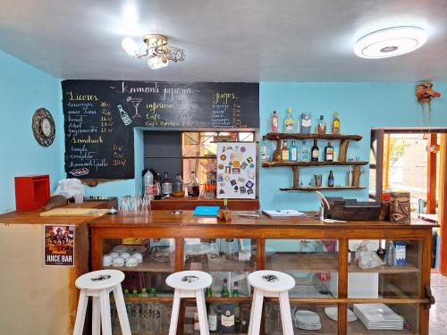 a restaurant with a counter with stools and a chalkboard at Kamanti Hostel in Pisac