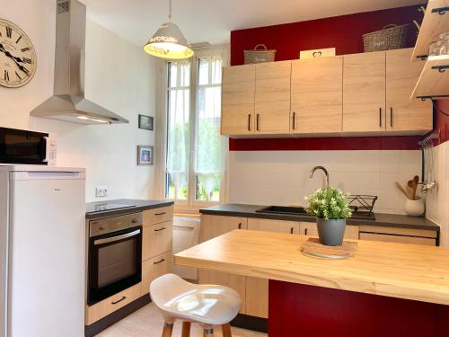 een keuken met een houten tafel en een aanrechtblad bij Charmant studio avec jardin, 2pers, centre-ville in Cauterets