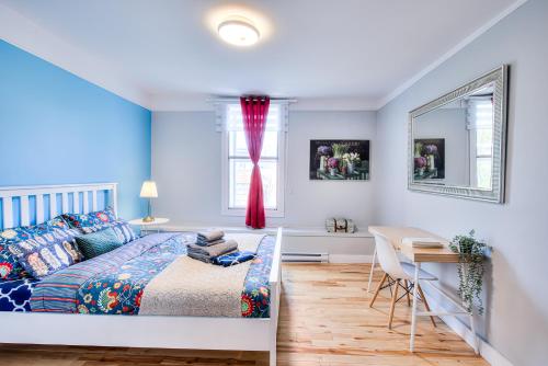 Un dormitorio con una cama y un escritorio y una ventana. en Premier destination for Big Groups MTL Vacation and Nightlife, en Montreal