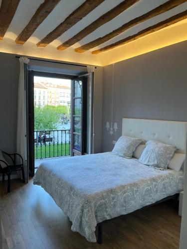 a bedroom with a bed and a large window at En el corazón de Pamplona in Pamplona