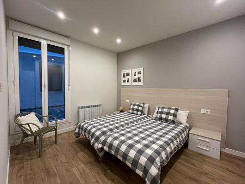 Un dormitorio con una cama, una silla y una ventana en En el corazón de Pamplona, en Pamplona