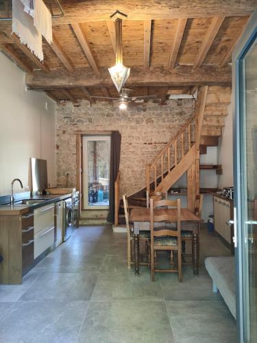 a kitchen with a wooden table and a staircase at Gîte du Longevent in Meximieux