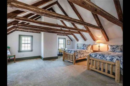 a attic room with two beds and a table at The Doctor 1781 House on the Litchfield Green in Litchfield