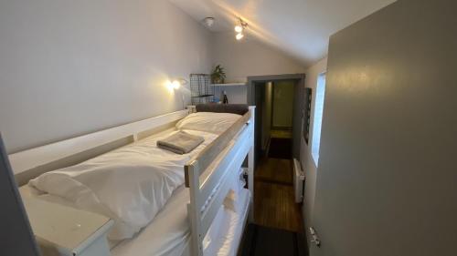 a bedroom with a bed with white sheets at EI8HT Brighton Guest Accommodation in Brighton & Hove