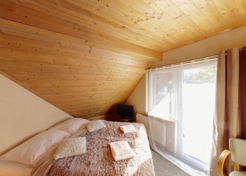 a bedroom with a bed in a room with a window at Dom Wypoczynkowy Topaz in Szklarska Poręba