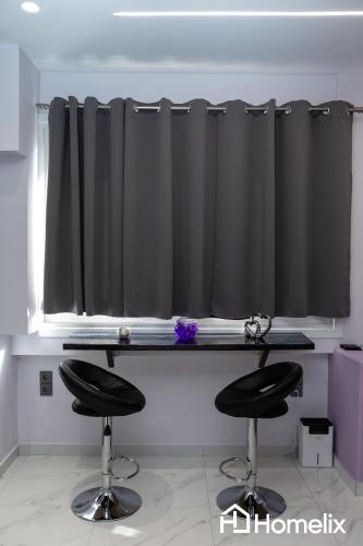 a desk with two black stools in front of a window at Modern studio in the city center in Chalkida