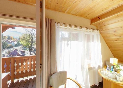 a room with a balcony with a large window at Dom Wypoczynkowy Topaz in Szklarska Poręba