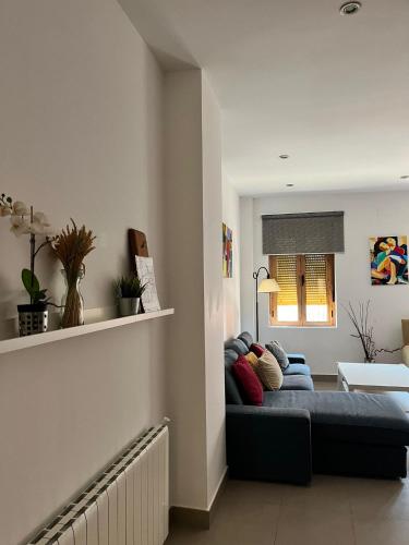 a living room with a blue couch and a window at Garrotera arco de Jerez in Zafra