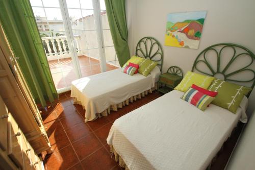 ミアミ・プラトーヤにあるARENDA Pino Alto Holiday Home Cristal 11のベッド2台とバルコニーが備わる客室です。