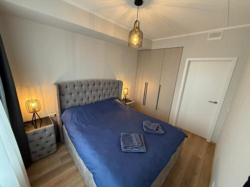 a bedroom with a blue bed with a blue blanket at Grēdu Rezidence in Riga