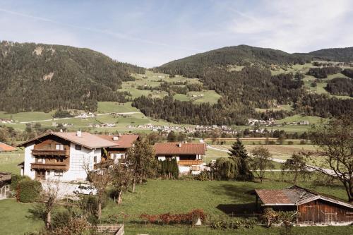 a group of houses in a valley with mountains at Lebe`schlitters - Das Ferienapartmenthaus im Zillertal in Schlitters