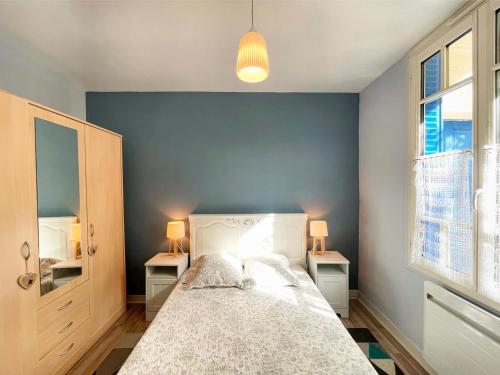 une chambre avec un grand lit avec deux tables de nuit dans l'établissement Charmant T2 avec jardin, 4 pers, coeur de village, à Cauterets