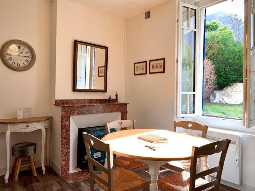une salle à manger avec une table et une cheminée dans l'établissement Charmant T2 avec jardin, 4 pers, coeur de village, à Cauterets
