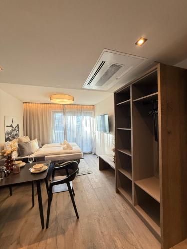 a room with a bed and a table and a dining room at LIVALPIN Alittlecosy in Garmisch-Partenkirchen