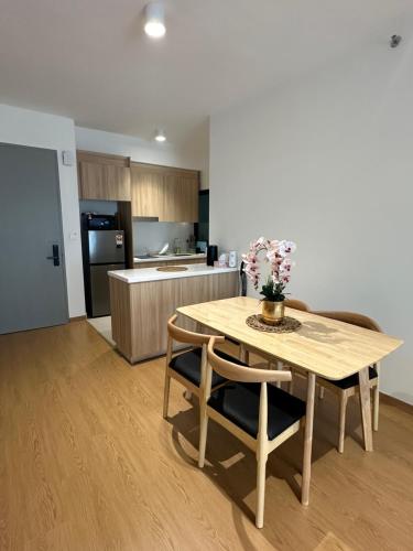 a kitchen with a wooden table with chairs and a table and a table at Maya Bay Splash Mania Pool View Cozy Homestay KLIA in Banting
