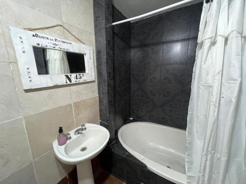 a bathroom with a sink and a tub and a toilet at Casa del Bosque in Mar del Plata