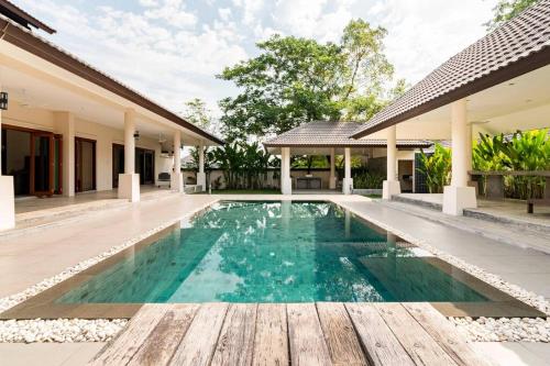 a swimming pool in front of a house at Art Luxe Homes Chiang Mai in Doi Saket
