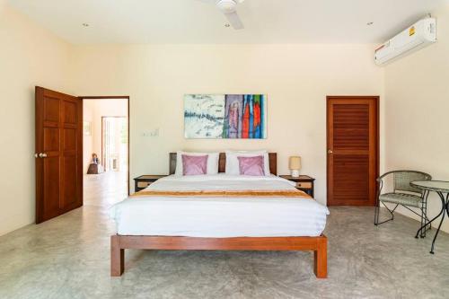a bedroom with a large white bed with pink pillows at Art Luxe Homes Chiang Mai in Doi Saket