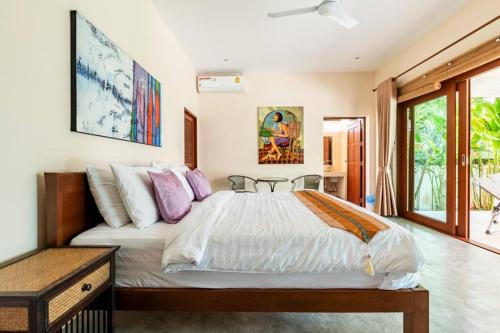 a bedroom with a large bed and a table at Art Luxe Homes Chiang Mai in Doi Saket
