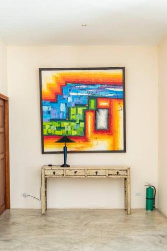 a painting on a wall with a table in a room at Art Luxe Homes Chiang Mai in Doi Saket