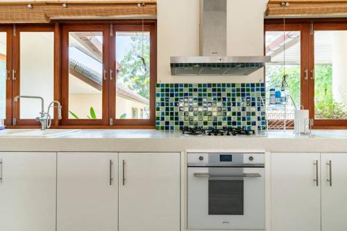 a kitchen with white cabinets and a stove top oven at Art Luxe Homes Chiang Mai in Doi Saket