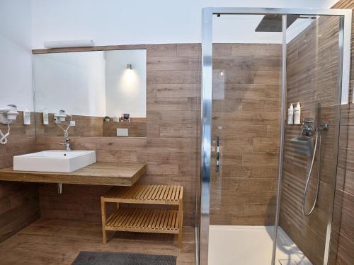 un baño con lavabo y ducha en Hotel Pordoi Passo Pordoi Vegetarian Hotel, en Canazei