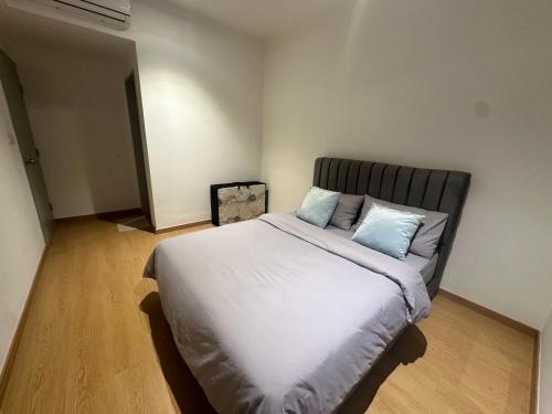 a bedroom with a bed with white sheets and blue pillows at Maya Bay Splash Mania Pool View Cozy Homestay KLIA in Banting