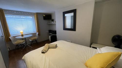 a bedroom with a white bed and a table and chairs at EI8HT Brighton Guest Accommodation in Brighton & Hove