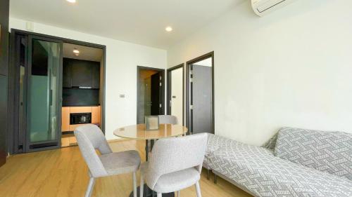 a living room with a table and chairs and a couch at Edge Central # UTrip in Pattaya