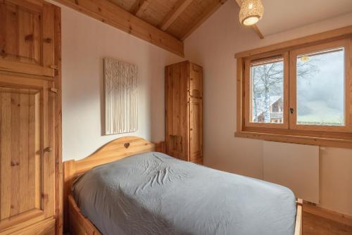 une chambre avec un lit et une fenêtre dans l'établissement Le Lou Clerouzy - 6 personnes, à Samoëns