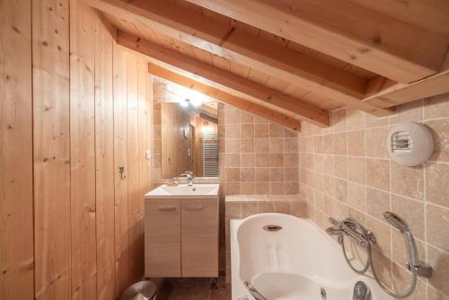 une salle de bain avec une baignoire et un lavabo dans l'établissement Le Lou Clerouzy - 6 personnes, à Samoëns