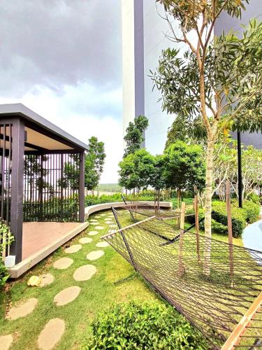 a fence in a park with a tower in the background at Maya Bay Splash Mania Pool View Cozy Homestay KLIA in Banting