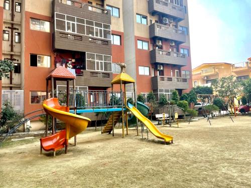 a playground in front of a building with slides at ZenRoofs- Brij Bhumi Haven in Vrindāvan