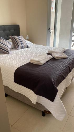a large bed with black and white sheets and pillows at CoWorking in Corrientes