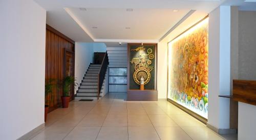 a hallway with a staircase and a painting on the wall at Hotel Aamis Villa in Pulpally