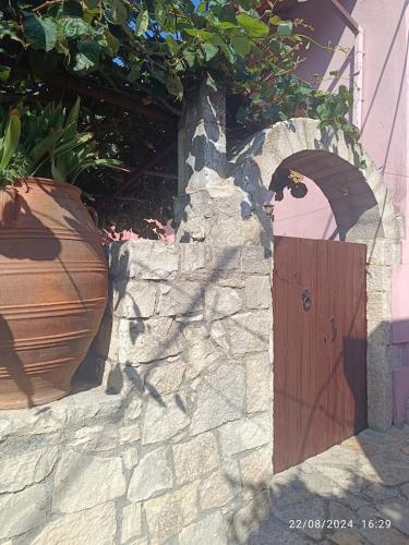 a stone wall with a wooden door and a vase at George Traditional Villa in Marouloú