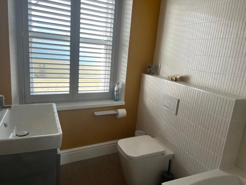 a bathroom with a toilet and a sink and a window at 18 Church Street in Salcombe