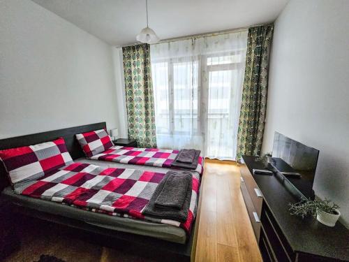 a bedroom with a bed with a checkered blanket at Mountain Dream A8 apartment in Borovets