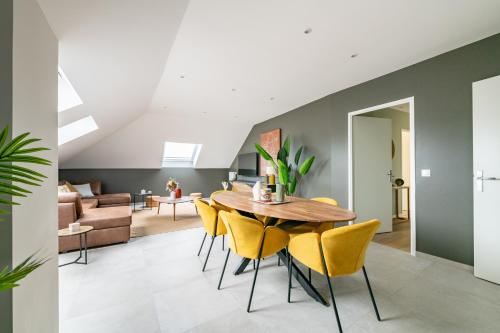 une salle à manger avec une table en bois et des chaises jaunes dans l'établissement Elégance Contemporaine, à Saint-Germain-sur-Morin