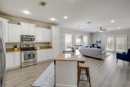a kitchen and living room with white cabinets at Relaxing Biloxi Vacation Rental Condo Near Beach! in Biloxi