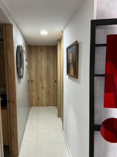 a small hallway with a door and a painting on a wall at Private Room Sabaneta in Sabaneta