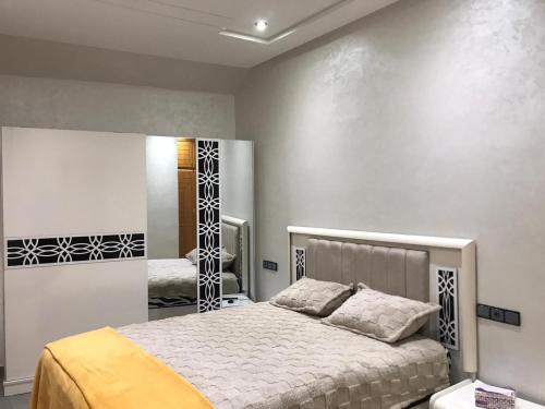 a bedroom with a bed and a mirror at AM Atlas Home in Ifrane