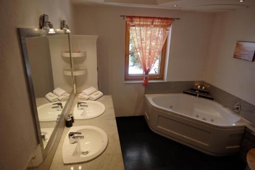 a bathroom with two sinks and a bath tub at Ferienhaus Stubaiblick in Neustift im Stubaital