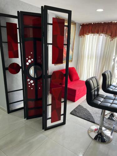 a living room with a red couch and a mirror at Private Room Sabaneta in Sabaneta