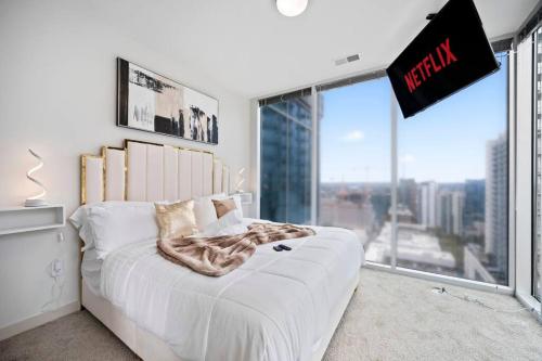 a bedroom with a bed with a large window at NEW! Luxury Champagne Towers Kingbed FreeParking in Atlanta