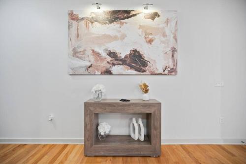 a living room with a wooden table with a painting on the wall at NEW! Luxury Champagne Towers Kingbed FreeParking in Atlanta