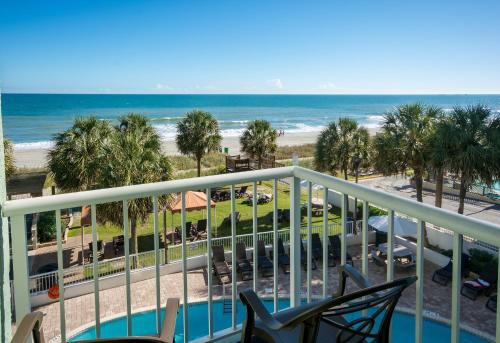 a view of the beach from the balcony of a resort at The Strand - A Boutique Resort in Myrtle Beach