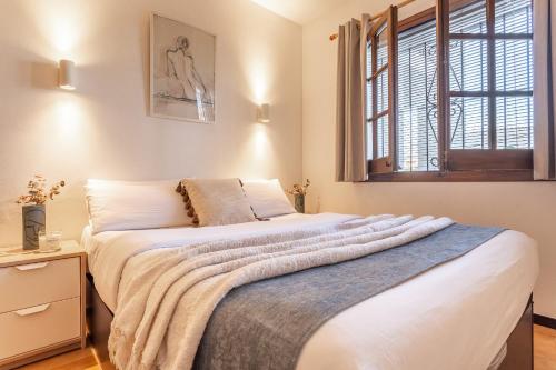 a bedroom with a bed with a blanket on it at Apartamento Gisela in L'Escala
