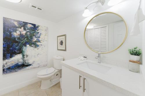 a white bathroom with a mirror and a toilet at Elegant Escape! in Boca Raton