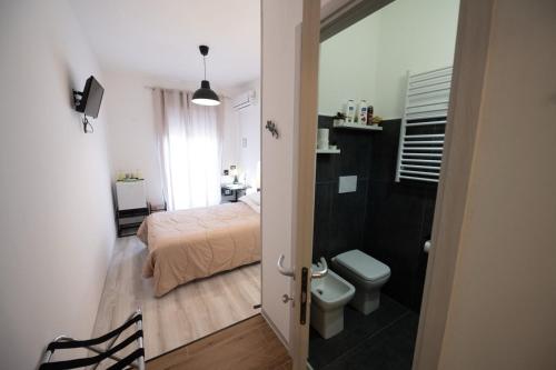 a bathroom with a bed and a toilet in a room at Luz de Salento B&B in Lecce